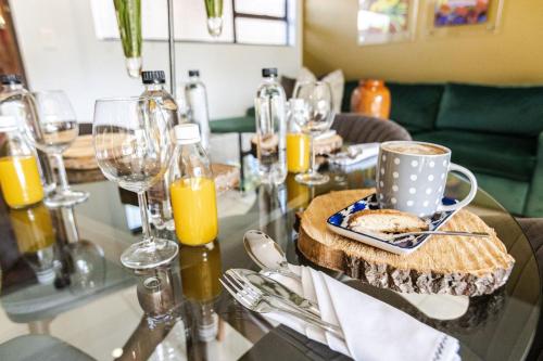 a table with a plate of bread and glasses of orange juice at Fleur de Lis Guesthouse in Krugersdorp