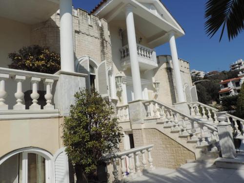 a large white house with stairs and a balcony at Villa Luxury in Kavala