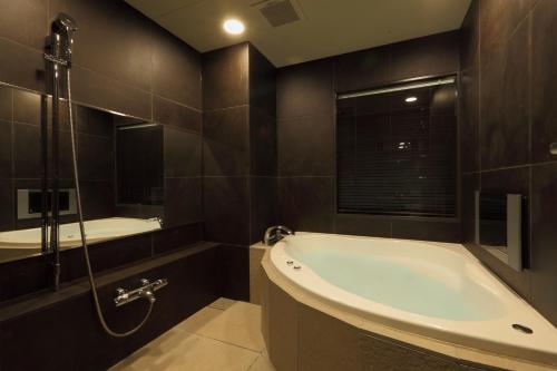 a bathroom with a bath tub and a sink at Centurion Hotel Grand Akasakamitsuke Station in Tokyo