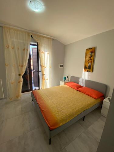 ein Schlafzimmer mit einem großen Bett mit einer orangefarbenen Decke in der Unterkunft B&B Santa Colomba in Benevento