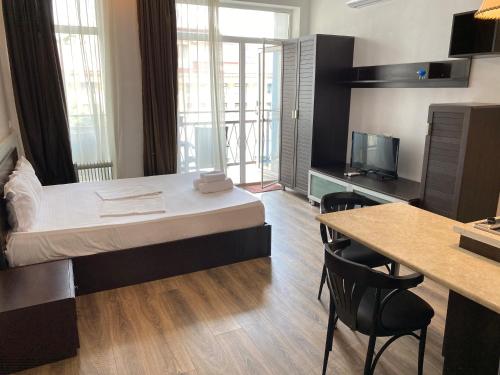 a hotel room with a bed and a table and chairs at Apartment In Batumi MGZAVREBI in Batumi