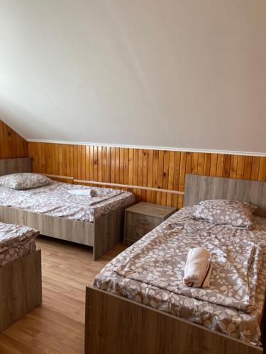 a bedroom with two beds and wooden walls at Homestay in Batumi Дом в Чакви in Chakvi