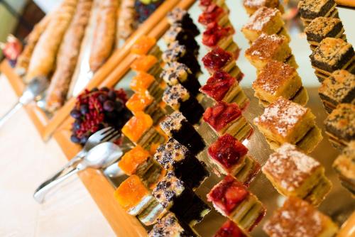 a display case with a bunch of different types of desserts at Hotel Finkennest - Panoramic Garden Resort in Schenna