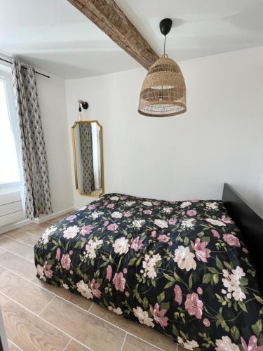 - une chambre avec un lit et une couverture fleurie dans l'établissement Superbe appartement au coeur du Mourillon refais à neuf proche des plage, à Toulon