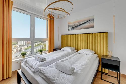 a bedroom with a large bed and a large window at Luxury Voyager - Sea View in Gdańsk