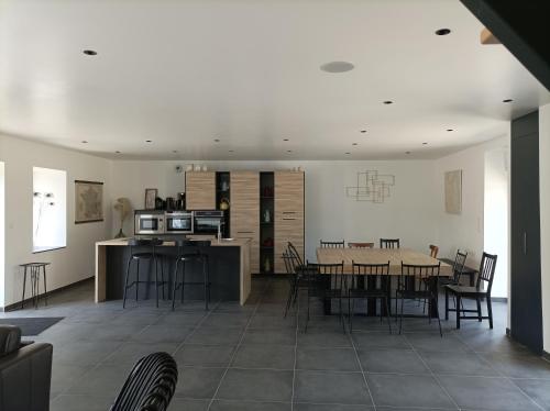 une cuisine et une salle à manger avec une table et des chaises dans l'établissement La grande baie spa privatif à 15 min du mt st Michel, à Pleine-Fougères
