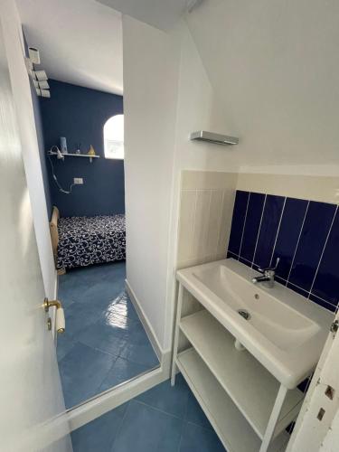 アナカプリにあるAttico Panoramicoの青の床のバスルーム(白い洗面台付)