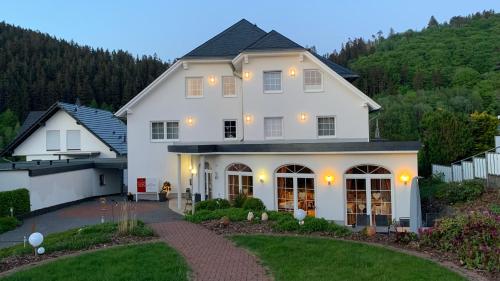 a large white house with a driveway at Landhaus Bergkrone in Willingen
