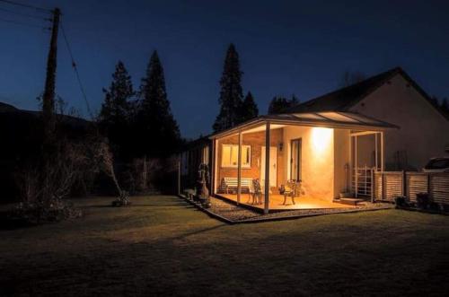 a small house with a lot of glass in a yard at Pinetree Cottage, dog friendly, Holiday let, Callander Invertrossachs in Callander
