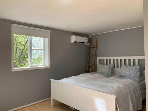 um quarto com uma cama branca e uma janela em Naturnära gård i Tyfta em Tyfta