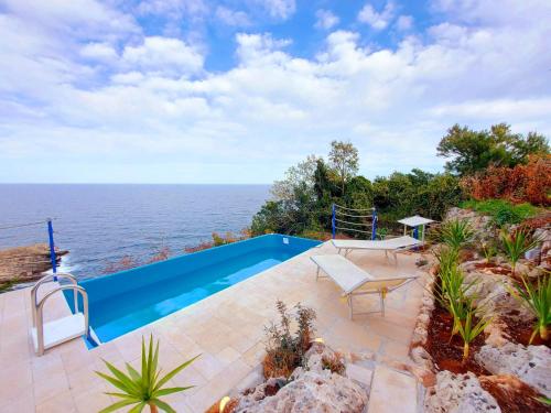 a swimming pool with a view of the ocean at VILLE GIRASOLI "VILLA NELLA BAIA" with PRIVATE SWIMMING POOL in Tricase