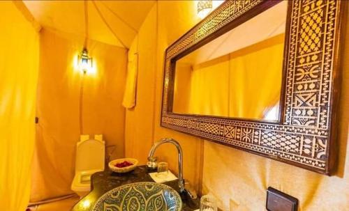 a bathroom with a sink and a mirror at desert camp sahara luxury in Merzouga