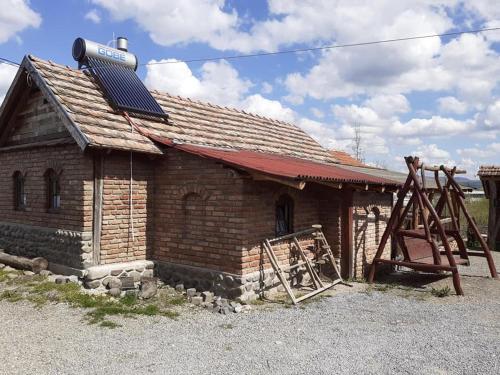 un pequeño edificio de ladrillo con techo solar y parque infantil en Casa Rustic Fehér & Fekete Vendégházak en Sovata