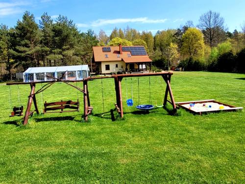 a play area with a house on top of it at Kemping i Domki nad stawem in Harsz