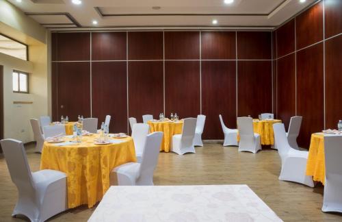 a banquet hall with tables and white chairs at Verona Hotel and Conference Center in Ruiru