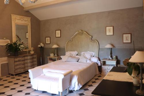 1 dormitorio con 1 cama grande con sábanas y almohadas blancas en La Banastiere en Vedène