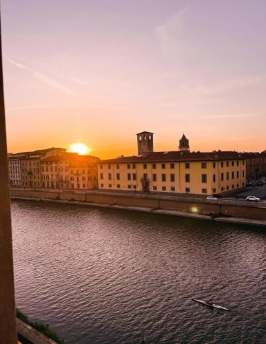 a sunset over a building next to a body of water at Il B&B dei viaggiatori in Pisa
