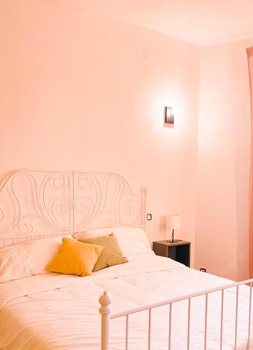 a bedroom with a white bed with yellow pillows at Il B&B dei viaggiatori in Pisa