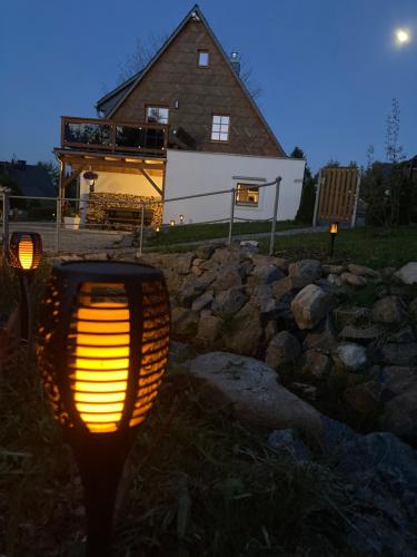 a light in front of a house with a stone wall at Erzgebirgshaus Zirbenliebe in Kurort Altenberg