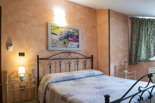 a bedroom with a bed and a picture on the wall at Case I Gerani in Alghero