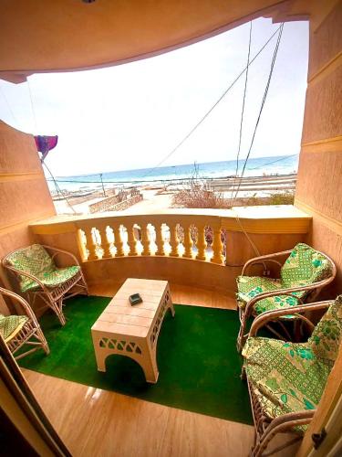 a balcony on a boat with a table and chairs at شقة بأطلالة علي الشاطئ in Alexandria