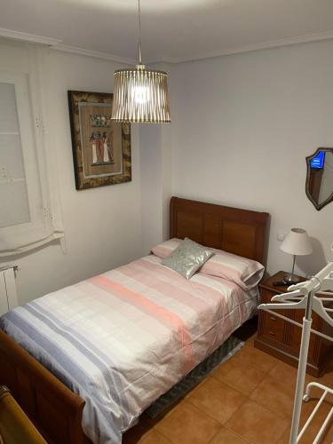 Schlafzimmer mit einem Bett und einem Kronleuchter in der Unterkunft A 10 minutos de las playas 1 in Puente Arce