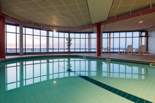 - une piscine intérieure dans un bâtiment avec fenêtres dans l'établissement Village Vacances 3* Ternélia Les Résidences d'Armor, à Douarnenez