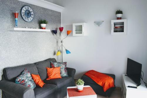 salon z kanapą i zegarem na ścianie w obiekcie Studio Paraiso w mieście Playa Blanca