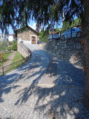 a road with a tree and a stone wall at Ca' del Barba in Domaso