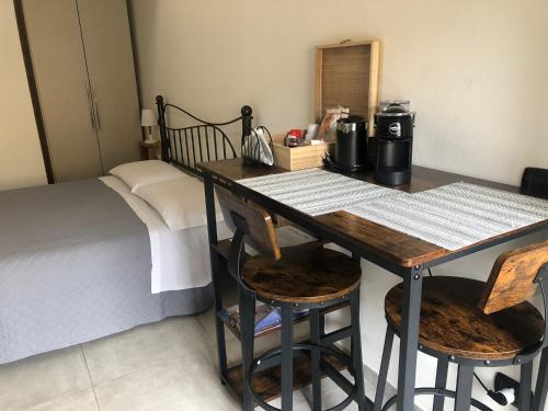 a room with a bed and a wooden table with chairs at le mura in Iglesias