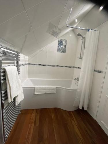 ein weißes Bad mit einer Badewanne und einer Dusche in der Unterkunft the Parc Place in Sarlat-la-Canéda