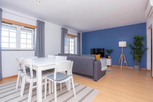a living room with a white table and chairs and a couch at Terrace Bairro Novo by Rent4All in Figueira da Foz