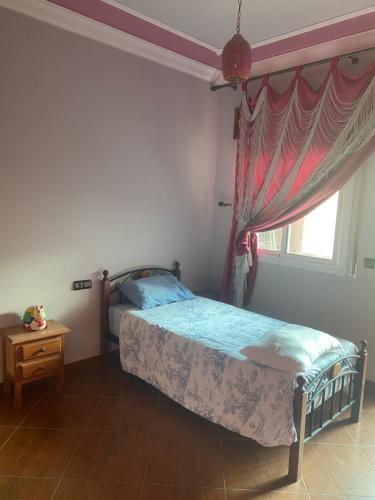 a bedroom with a bed and a window at La colombe appartement in Tétouan