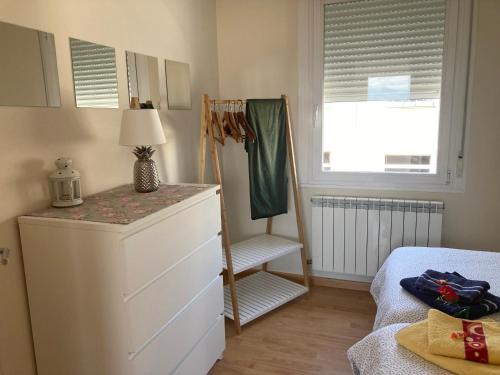 1 dormitorio con vestidor, cama y ventana en ATICO LOGROÑO CENTRO con garaje incluido 2, en Logroño