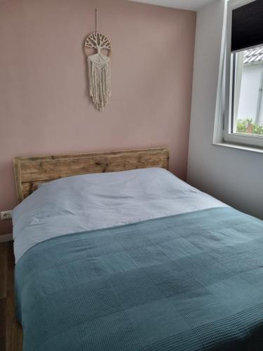 een slaapkamer met een bed met een blauw dekbed en een raam bij Vakantie vieren aan het Sneekermeer in Offingawier