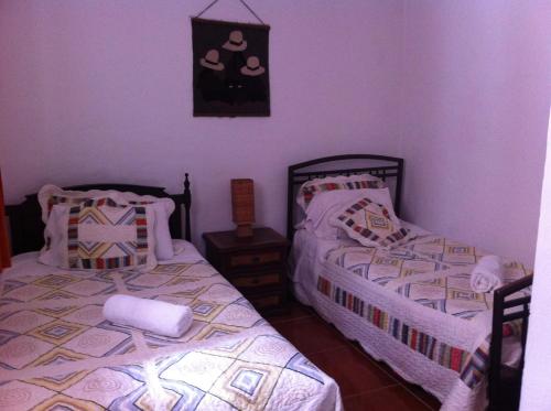 two beds in a room with purple walls at Hotel Los Frayles in Villa de Leyva