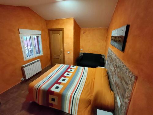een slaapkamer met een bed met een kleurrijke deken bij Casa el Susurro in Villamediana de Iregua