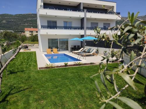 a house with a swimming pool and a yard at NEW VILLA DAVID, WI-FI, IPTV, 5 bedrooms, 4 bathrooms in Kaštela