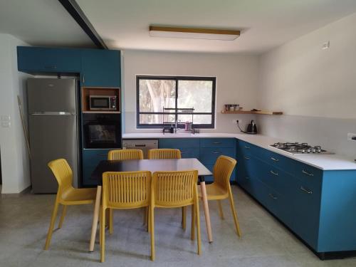 a kitchen with blue cabinets and a table and chairs at הבית של סבתא סבתא לילי ליד הנחל in Beit Hillel