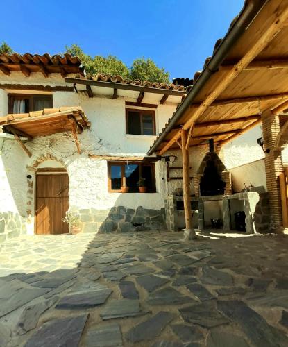 a house with a stone courtyard in front of it at Casa los chaparrales in Los Anchos