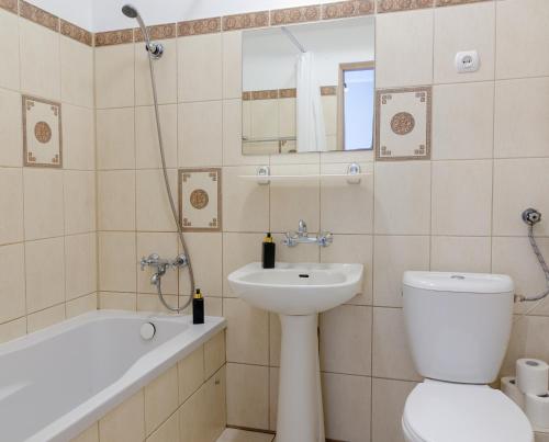a bathroom with a toilet and a sink and a bath tub at Holiday Home SLAVIA NEW 600 z widokiem na morze in Międzyzdroje
