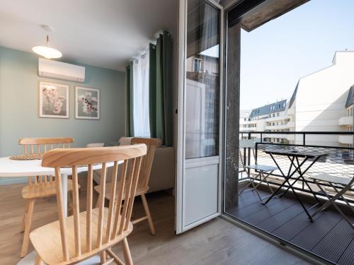 une chambre avec une table, des chaises et une porte en verre dans l'établissement Apparts Seasons - Saint Étienne - La Terrasse, à Saint-Étienne