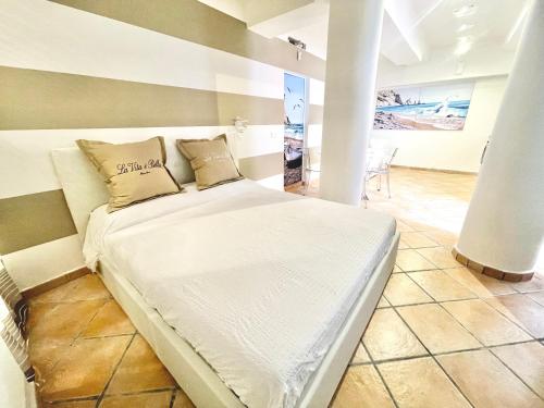 1 cama blanca con 2 almohadas en una habitación en Maison Del Conero - Ombrellone e Lettini in Spiaggia Inclusi, en Numana