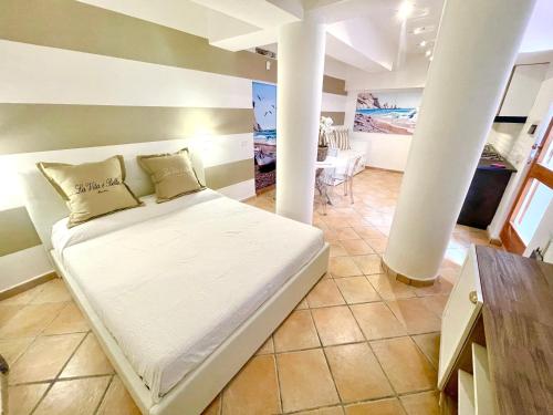 a bed in a room with a column at Maison Del Conero - Ombrellone e Lettini in Spiaggia Inclusi in Numana