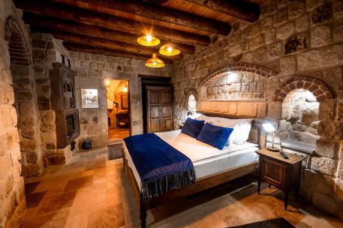 a bedroom with a large bed in a stone wall at Ürgüp Cave Suites in Urgup
