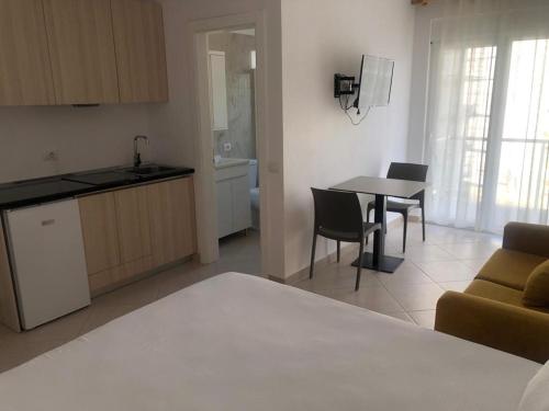 a kitchen and a living room with a table and chairs at Hotel MARIO, Shengjin in Shëngjin
