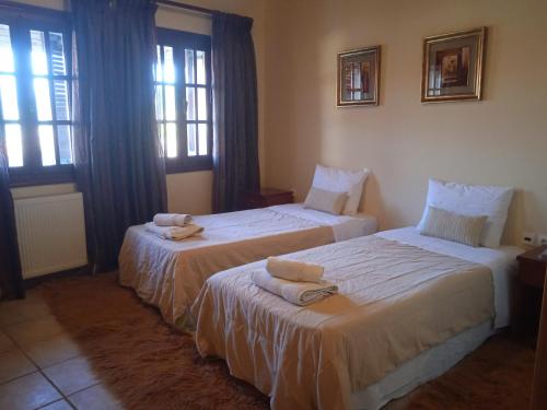 two beds in a hotel room with towels on them at Thiamis Guesthouse in Doliana