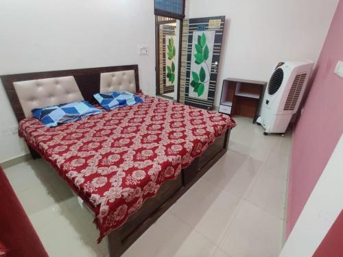 Un dormitorio con una gran cama roja con almohadas azules en JK Royal Palace And Lodge, en Allahābād