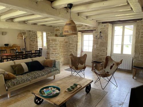 a living room with a couch and chairs and a table at La Closerie de Gigny Maison Templiere avec Piscine,jacuzzi in Gigny
