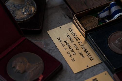a box of coins with a label on it at Rafalias Mansion in Hydra
